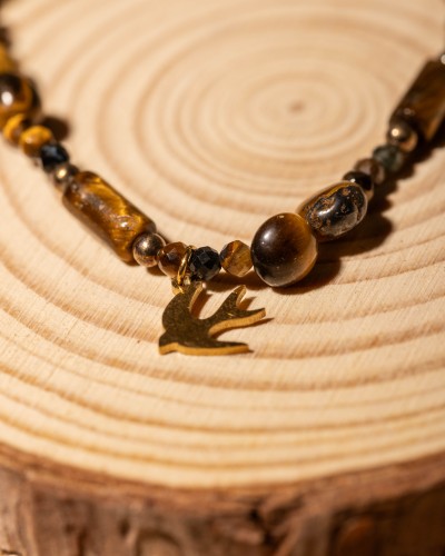 Bransoletka z naturalnego tygrysiego oka z zawieszką jaskółki to wyjątkowa biżuteria handmade w stylu boho, która zachwyca ciepłymi refleksami kamienia i symboliką wolności.