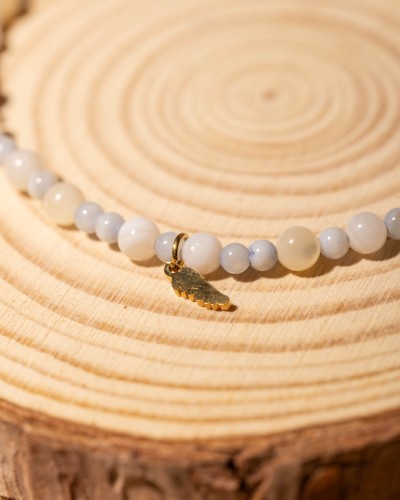 Bransoletka z białej i błękitnej masy perłowej ze skrzydełkiem to delikatna biżuteria handmade, która zachwyca subtelnym blaskiem, elegancją i ponadczasowym stylem boho.