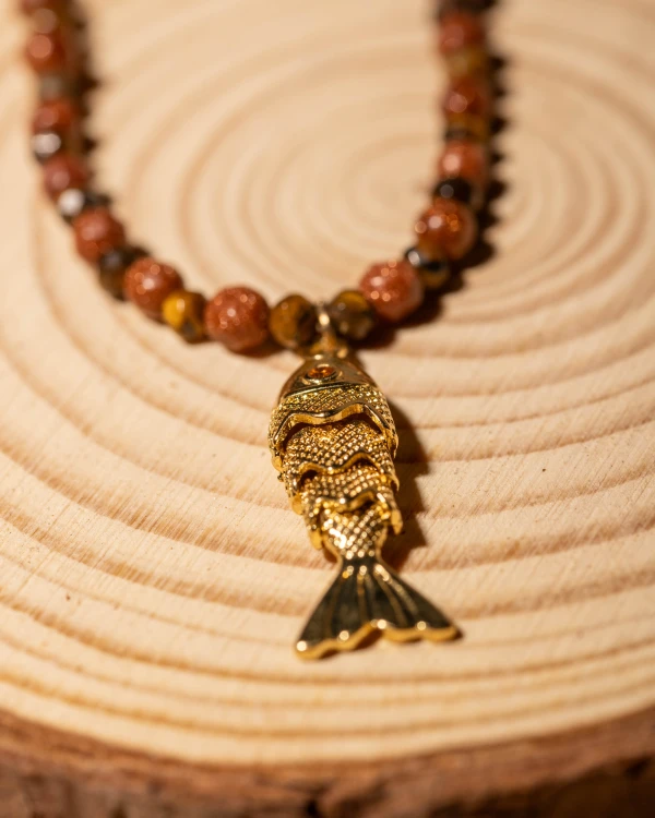 Naszyjnik z piasku pustyni i złotej rybki koi to wyjątkowa biżuteria handmade w stylu boho, która łączy naturalny blask kamieni, symbolikę i ponadczasową elegancję.